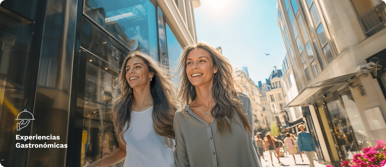Dos mujeres jóvenes caminando por la calle y sonriendo