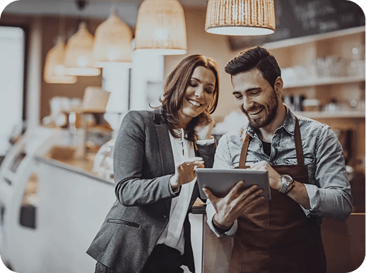 Dos personas mirando un ipad y sonriendo