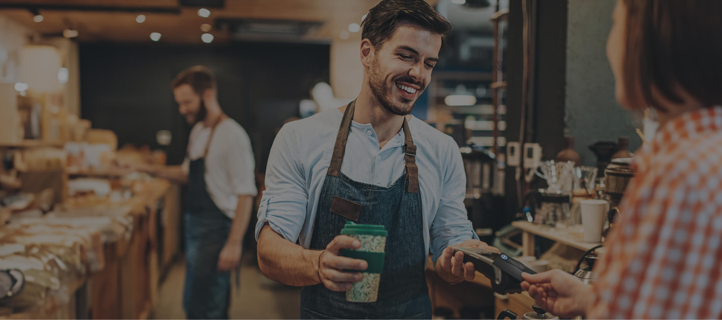 Persona pagando en un negocio, empleado cobrando