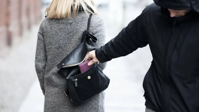 Evitar robo de tarjeta de crédito: Una persona robando una cartera de una chica