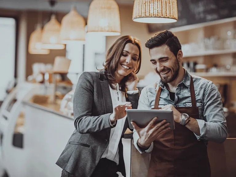 Afiliación establecimiento Diners Club: Persona y un mesero realizando una orden en una tablet