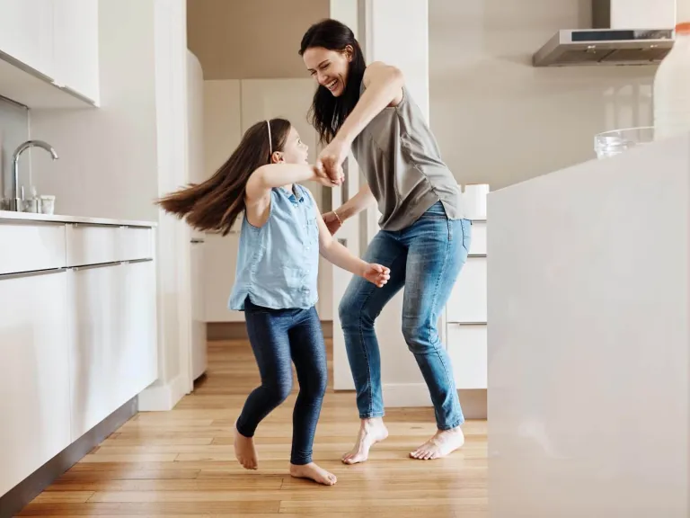 Diners Club Aadvantage asistencia para el hogar: Una madre y su hija bailando en la cocina
