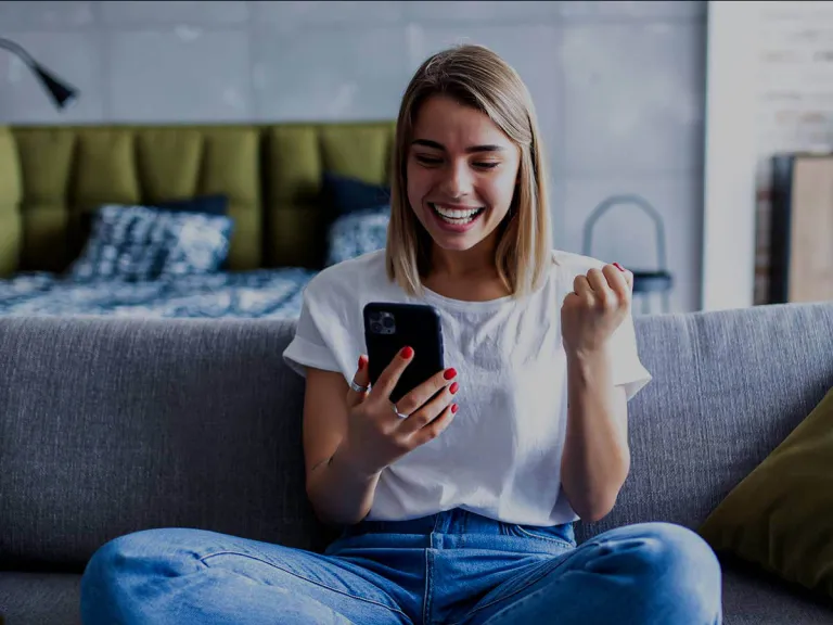 Chica sentada con celular sonriendo