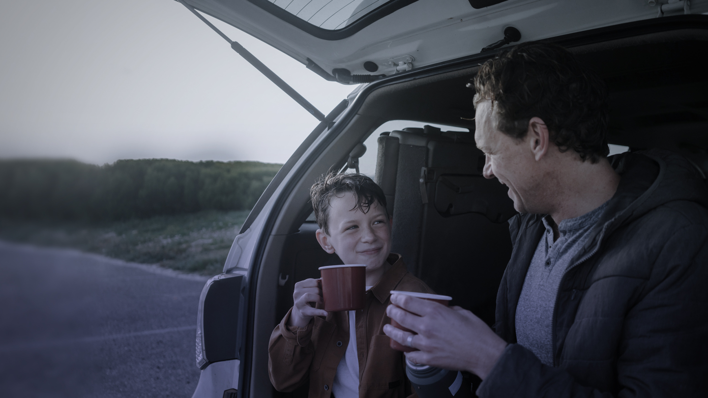 Ofertas y novedades Diners Club: Padre e hijo tomando una taza en su auto