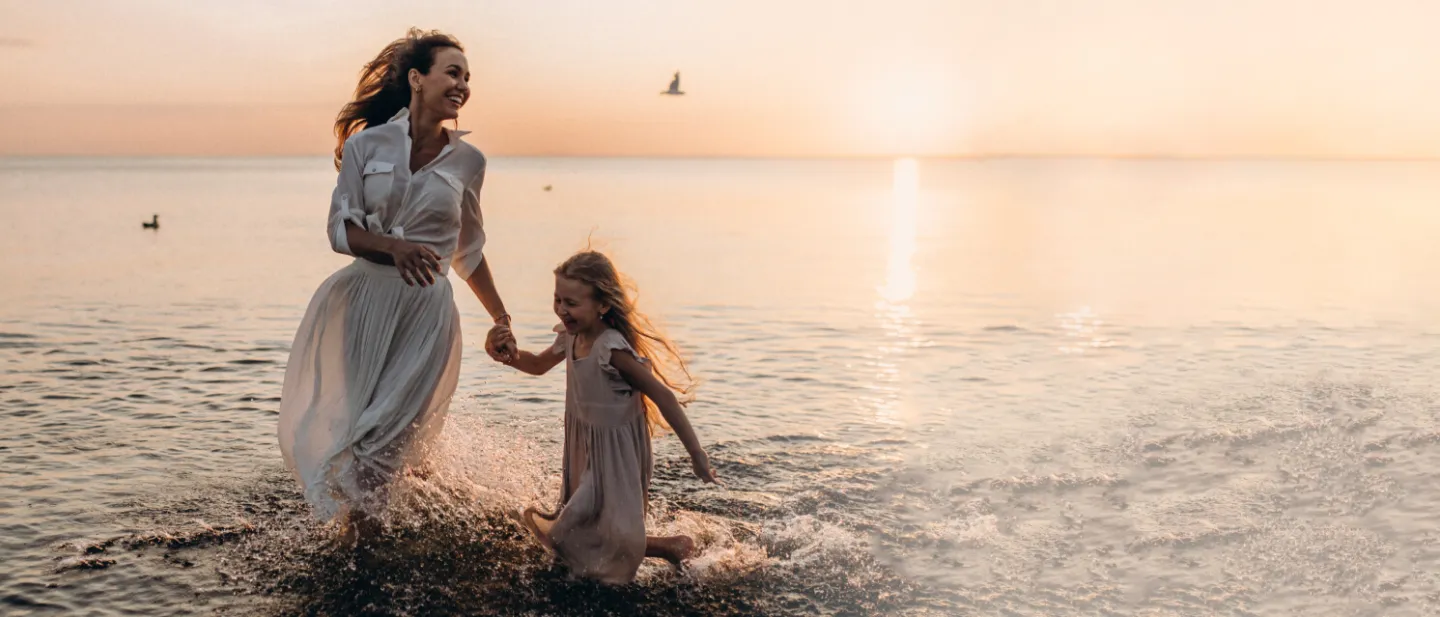 Madre e hija en la playa al atardecer