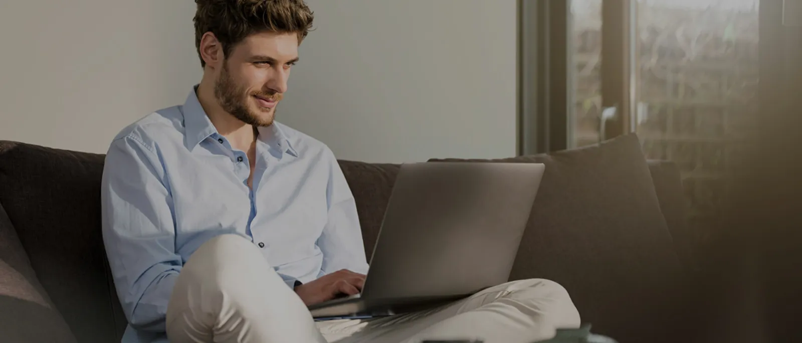 Hombre con una computadora sentado.